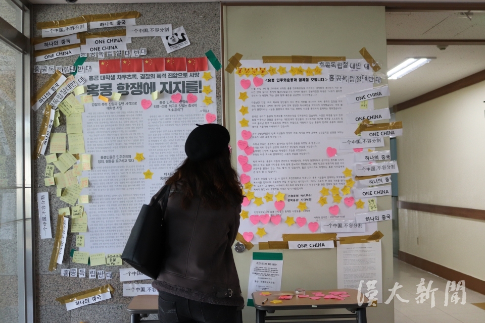 지난 14일, 지나가던 학생이 인문대 1층에 설치된 레논 월을 보고 있는 모습이다.